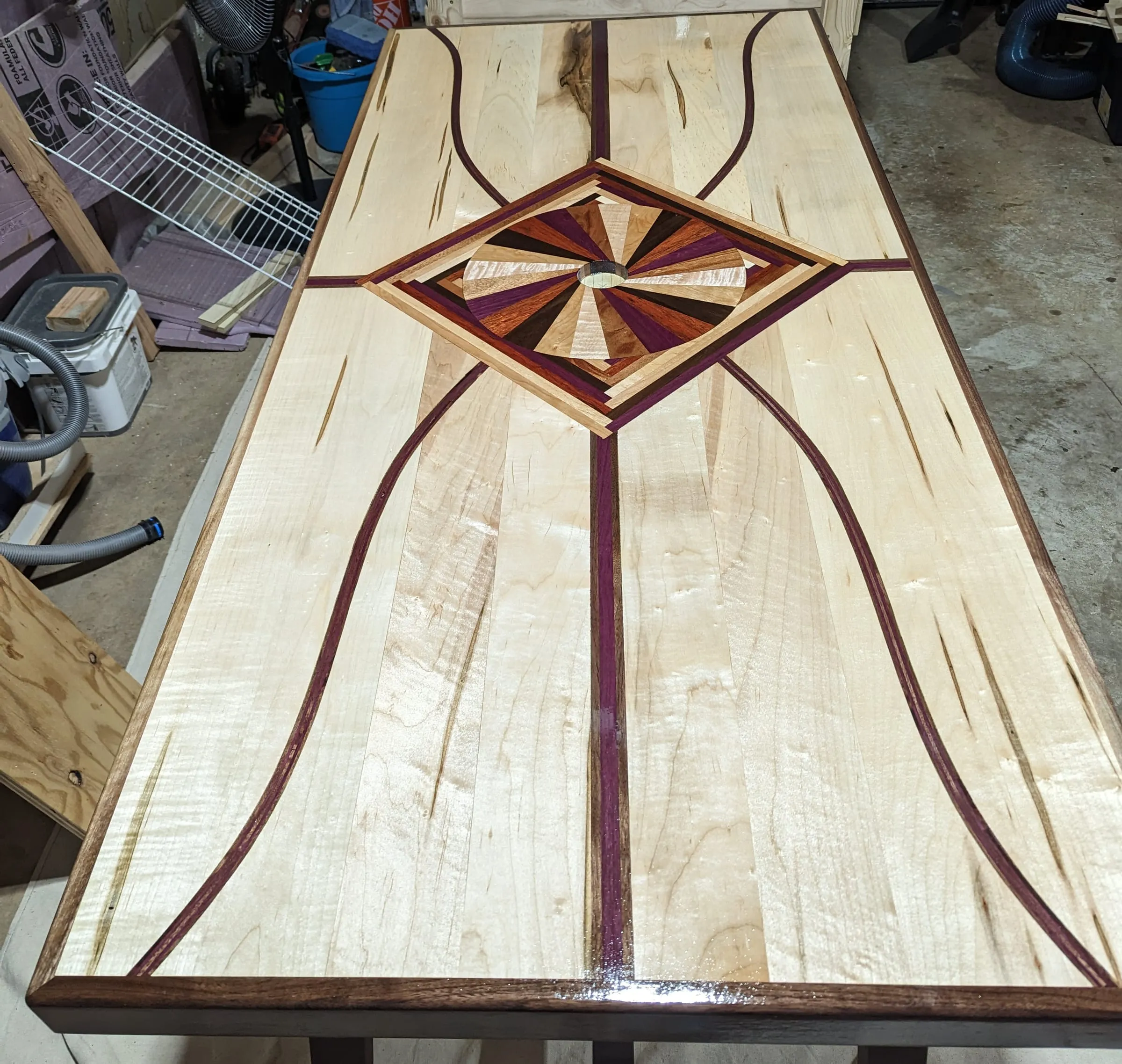 The Starburst Picnic Table — Curved purpleheart and walnut inlays running the length of the top