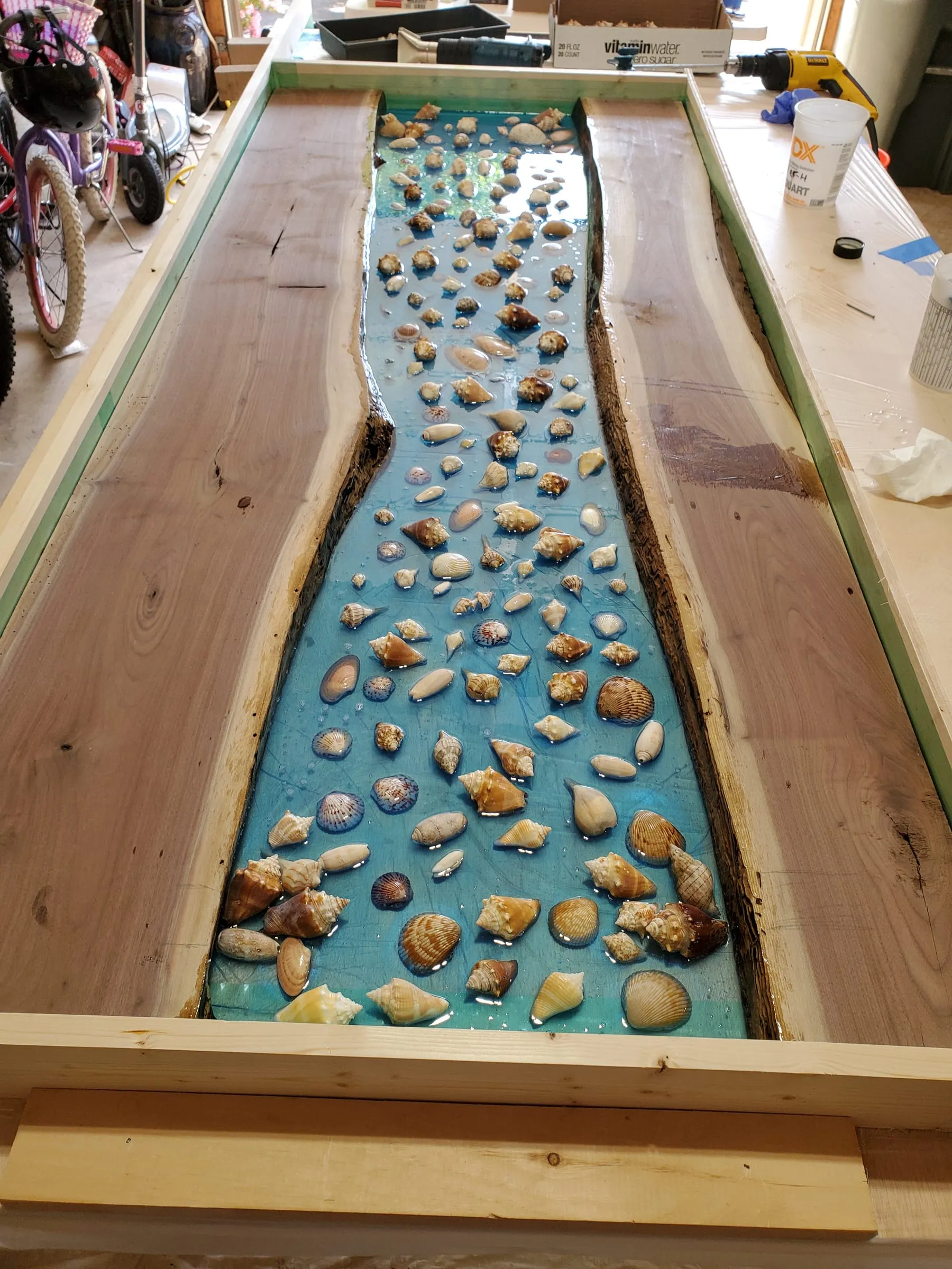 The Outdoor River Table — Shells laid into the river before the pour
