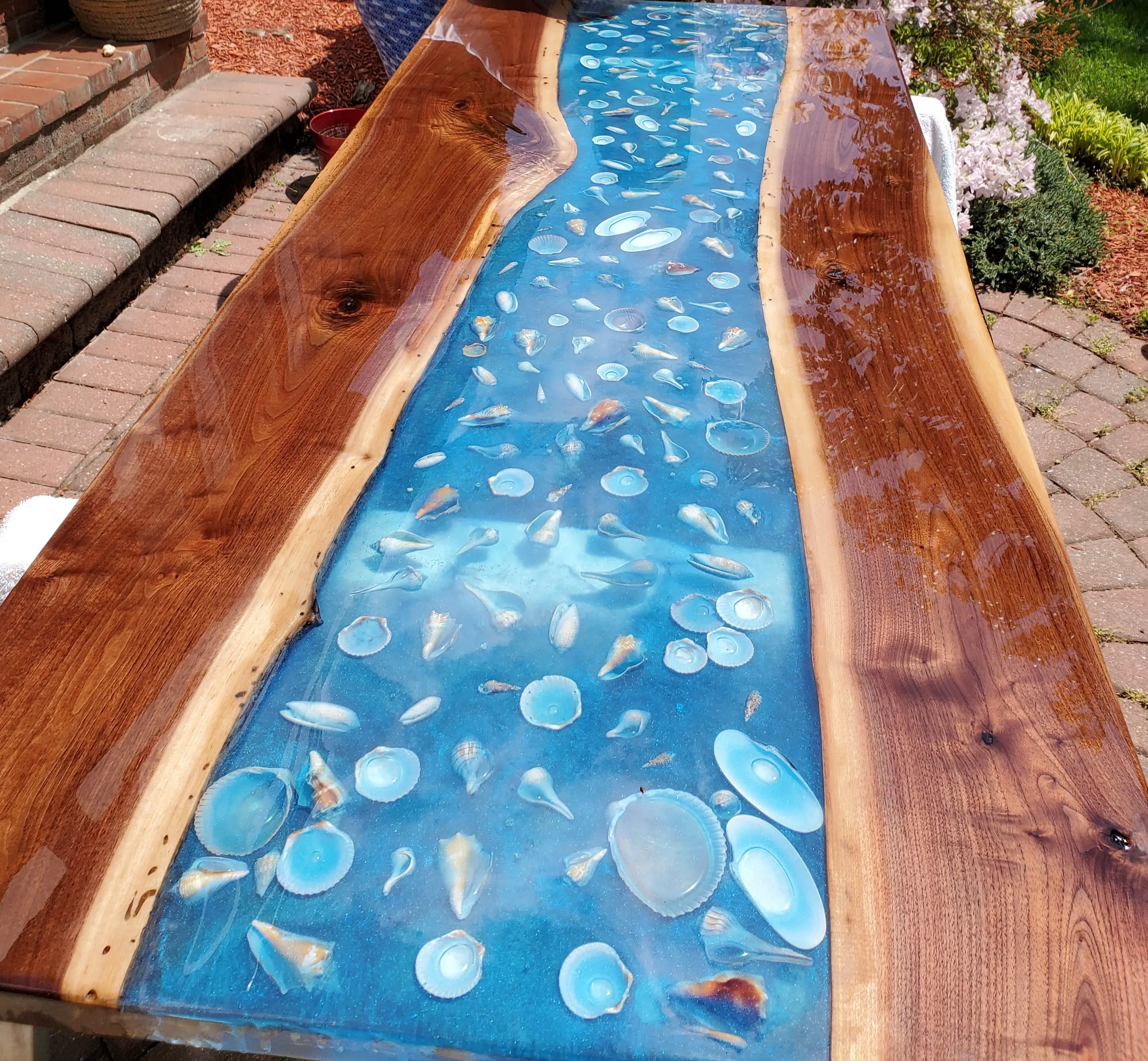 The Outdoor River Table — The finished top: walnut slabs and the shell river