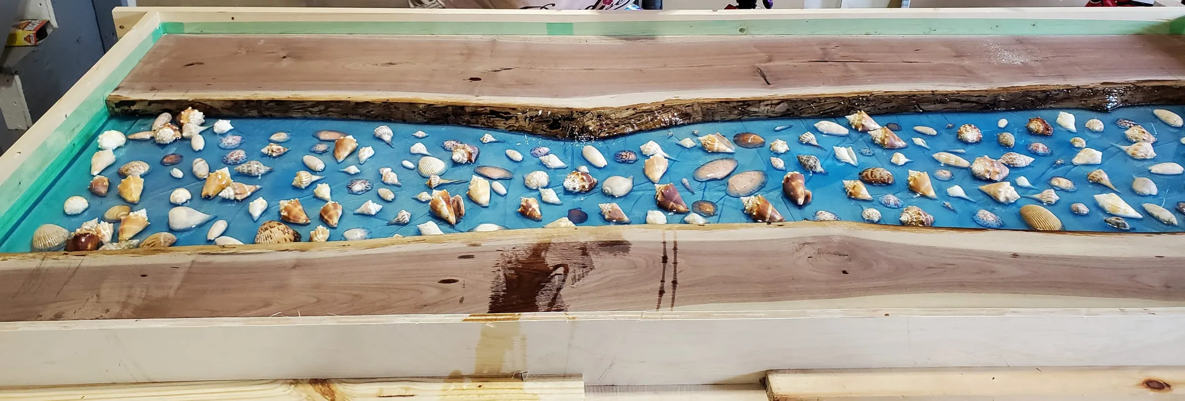 The Outdoor River Table — Shell-strewn river curing in its frame